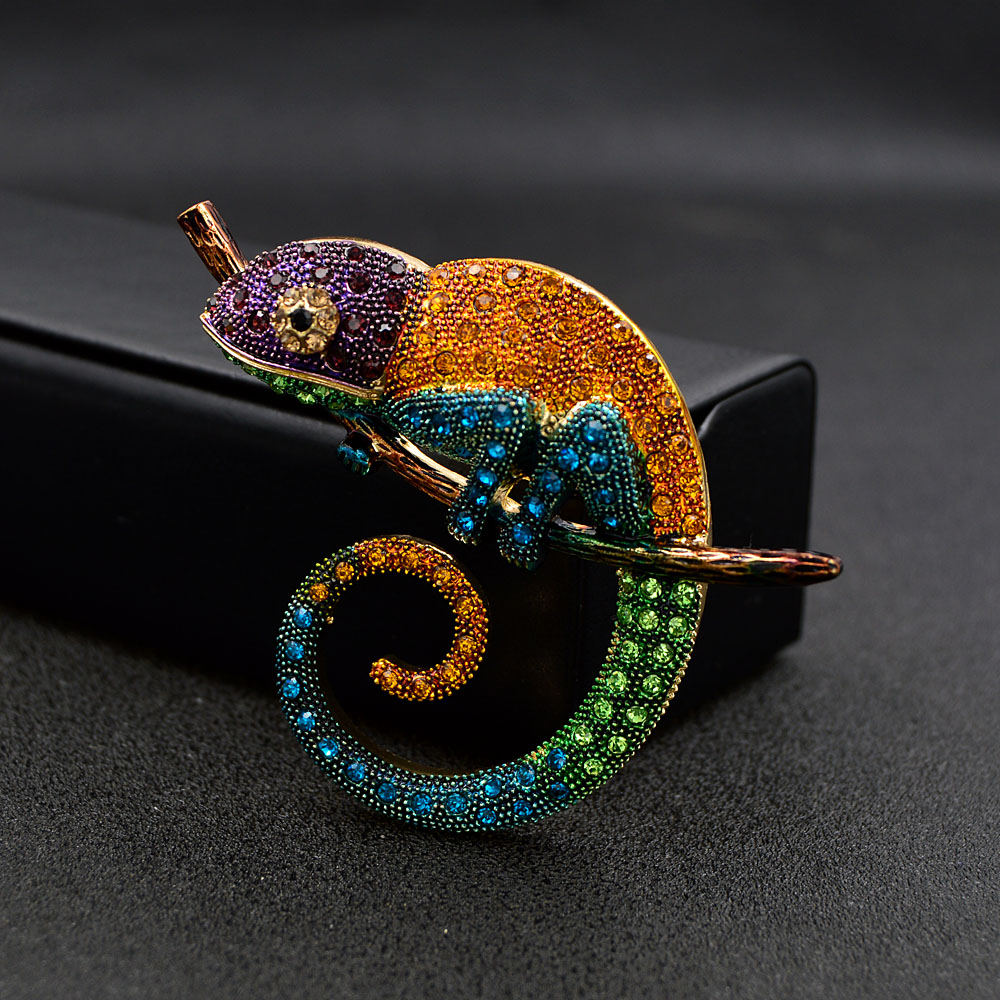 Broche caméléon coloré en métal avec strass multicolores violet, orange, bleu et vert, détail sur la queue enroulée et finition soignée