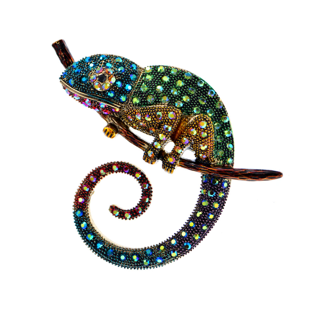 Broche caméléon coloré en métal orné de strass bleus, verts et jaunes, vue de profil montrant la queue en spirale et les détails scintillants