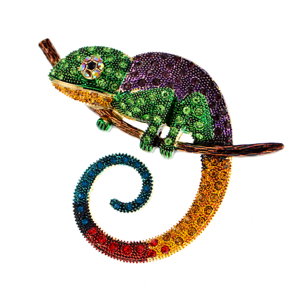 Broche caméléon coloré en métal orné de strass multicolores posée sur une branche