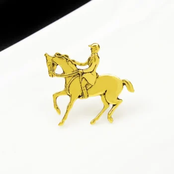 Broche Cavalier dorée en métal représentant un cavalier à cheval en position de dressage