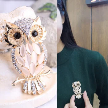 Broche chouette fantaisie dorée avec strass et pierres roses en forme de feuilles, portée sur un pull vert