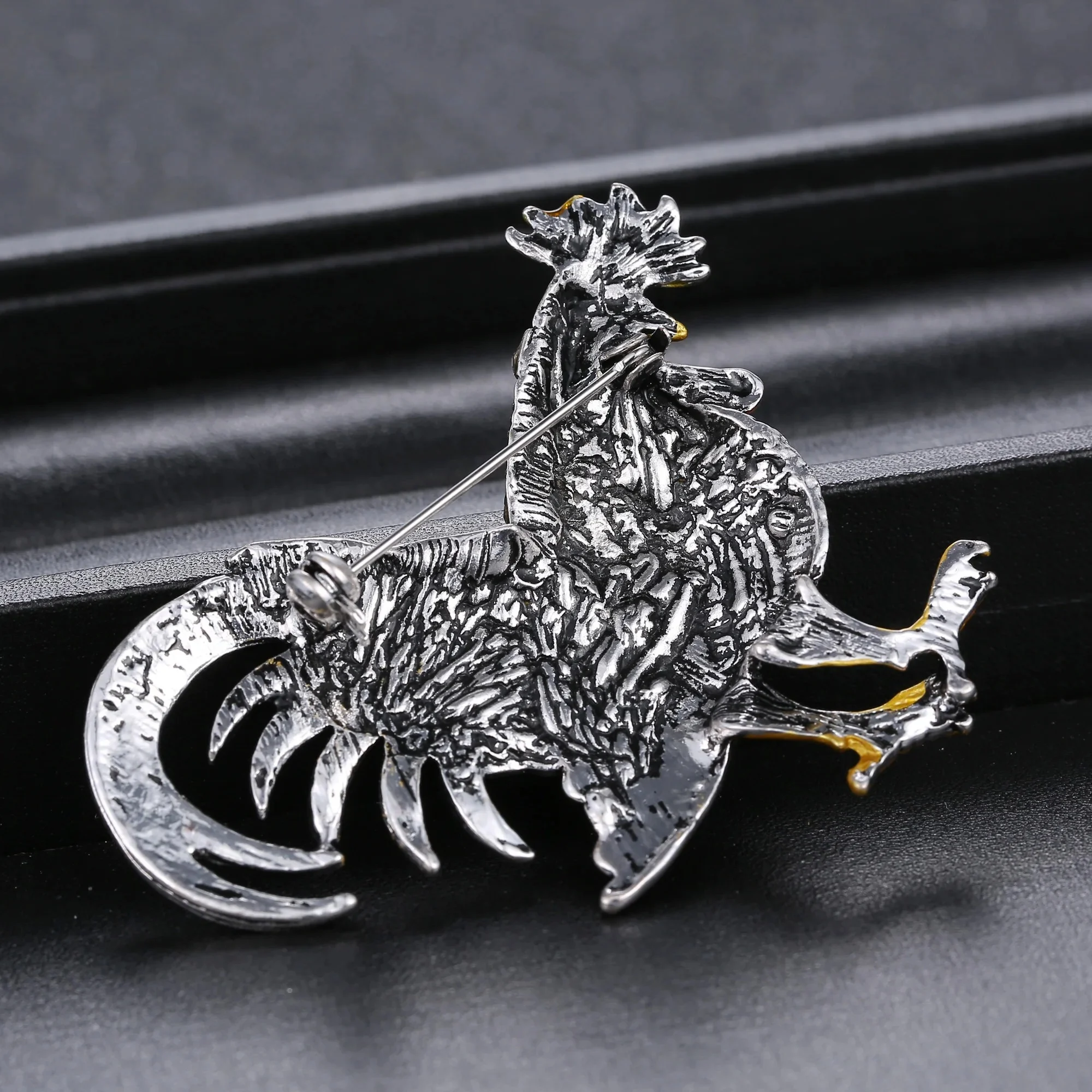Broche coq fantaisie en métal argenté avec détails texturés et finition soignée
