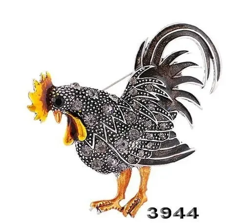 Broche Coq Fantaisie en métal noir et argenté avec détails orange, vue de profil montrant le plumage stylisé et le bec ouvert