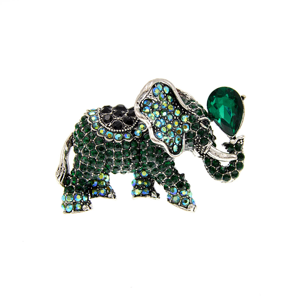 Broche éléphant fantaisie en métal argenté ornée de cristaux verts et noirs avec un cristal vert émeraude en forme de goutte sur la trompe