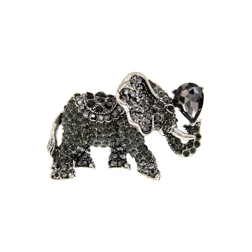 Broche éléphant fantaisie en métal argenté ornée de strass noirs, vue de profil avec détail de la trompe levée et pierre noire en forme de goutte