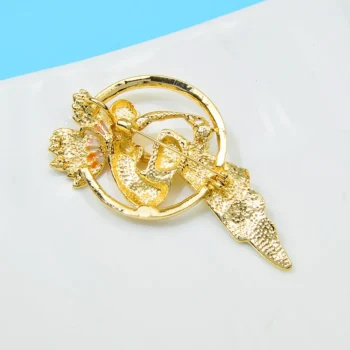 Broche femme abstraite en métal doré avec motif circulaire et formes texturées