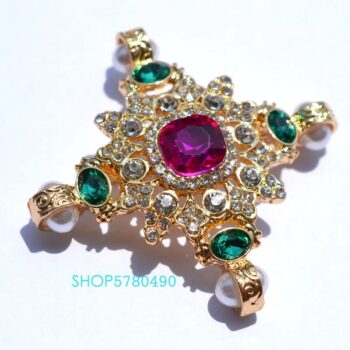 Broche femme en forme d'étoile en métal doré avec pierre strass rouge centrale et strass verts aux extrémités, décorée de petits cristaux transparents