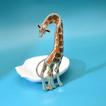 Broche girafe fantaisie en métal argenté avec émail orange et marron, vue de face légèrement inclinée sur fond bleu
