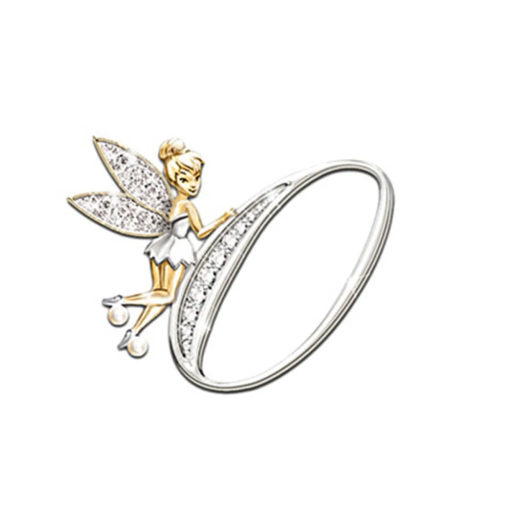 Broche Grandes Lettres en forme de lettre O avec fée dorée et ailes incrustées de strass, finition argentée et dorée, détail soigné