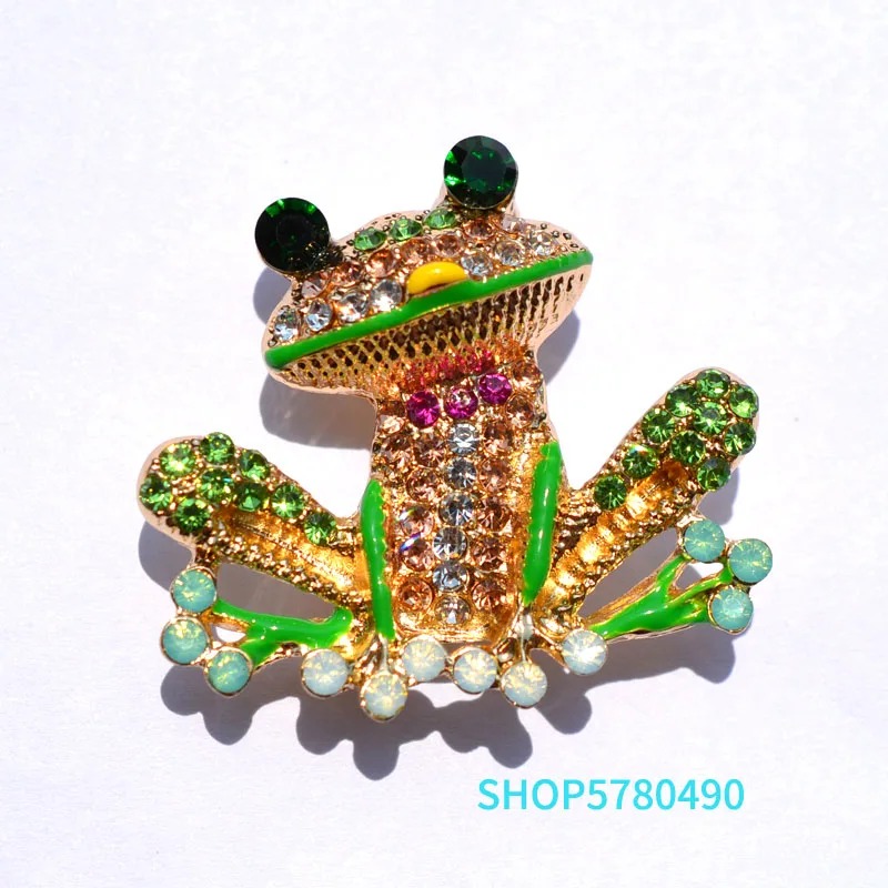Broche grenouille originale en métal doré avec strass verts, blancs et roses, détail soigné et finition élégante