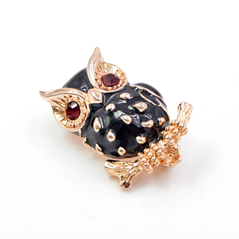 Broche hibou noir en métal doré avec détails en strass rouges et corps texturé