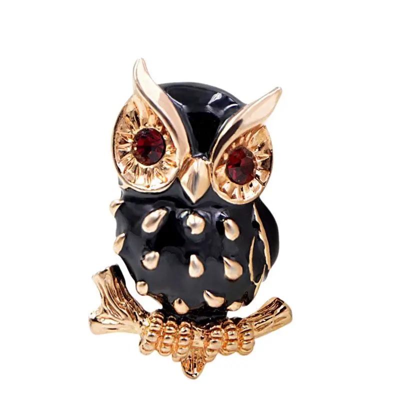 Broche hibou noir en métal doré avec yeux rouges et détails en relief