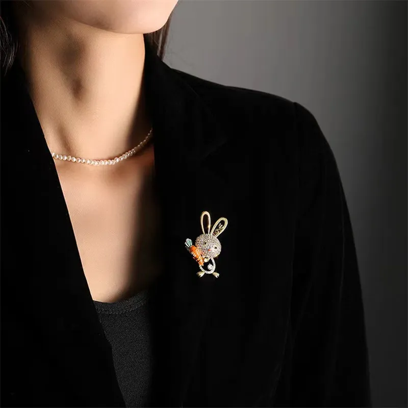 Broche lapin et carotte en strass portée sur un vêtement noir, vue rapprochée de l'accessoire de mode