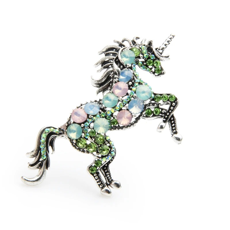 Broche licorne femme en métal argenté ornée de pierres vertes, roses et bleues, détail soigné du motif licorne en position cabrée