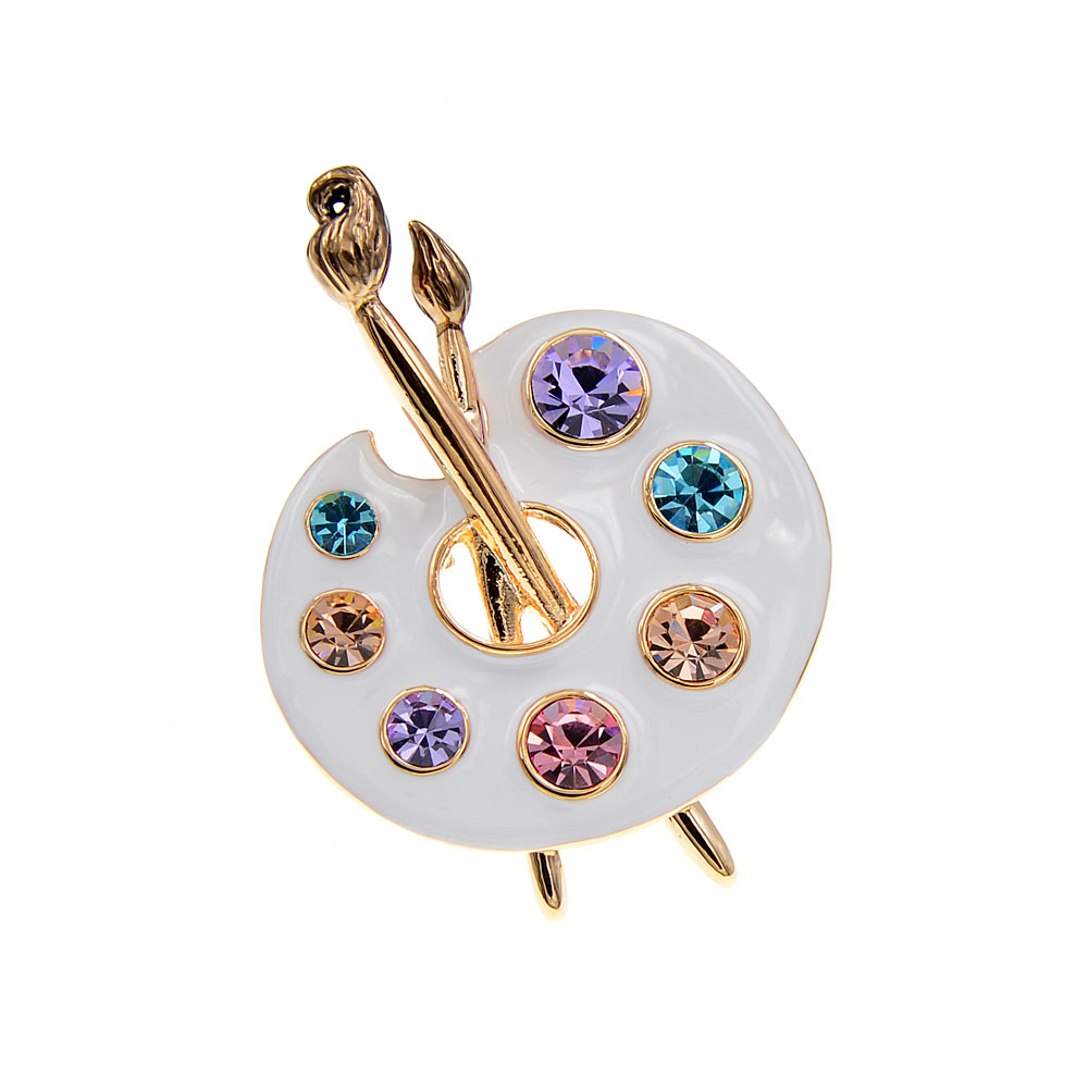 Broche palette de peintre blanche en métal doré avec strass colorés et pinceaux décoratifs