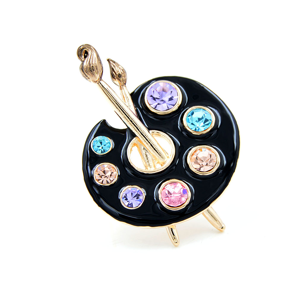 Broche palette de peintre noire en métal doré avec pierres colorées et pinceaux décoratifs