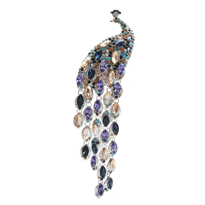 Broche paon femme en métal argenté avec pierres bleues, violettes et beiges, motif plume détaillé