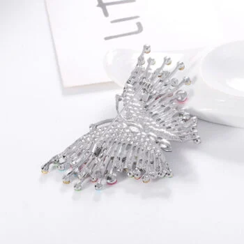 Broche papillon coloré en métal argenté avec strass multicolores, détail soigné des ailes ajourées