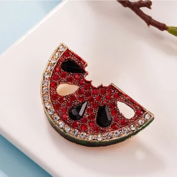 Broche pastèque en forme de tranche avec strass rouges, noirs et blancs, détail soigné et finition élégante