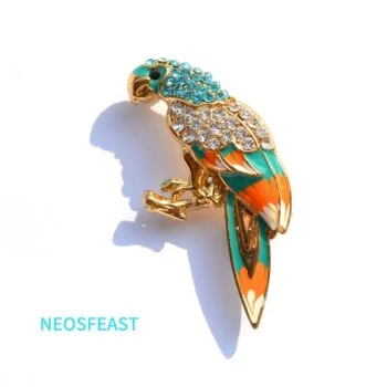 Broche perroquet en métal doré avec strass turquoise et blancs, motif coloré orange et vert, détail soigné