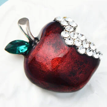Broche pomme rouge en métal avec feuille verte en cristal et décoration en strass blancs sur le dessus