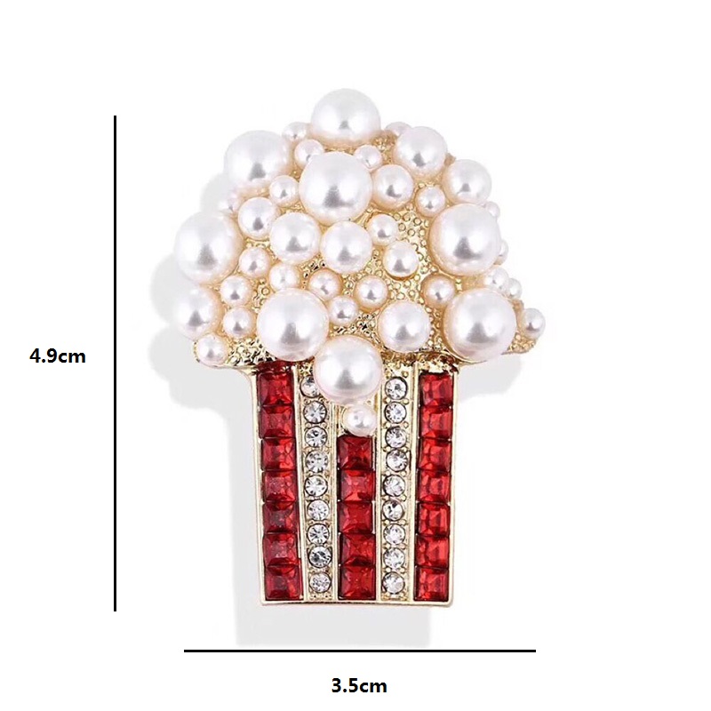 Broche Pop Corn fantaisie en métal avec perles blanches et strass rouges et transparents, dimensions 4,9 cm sur 3,5 cm