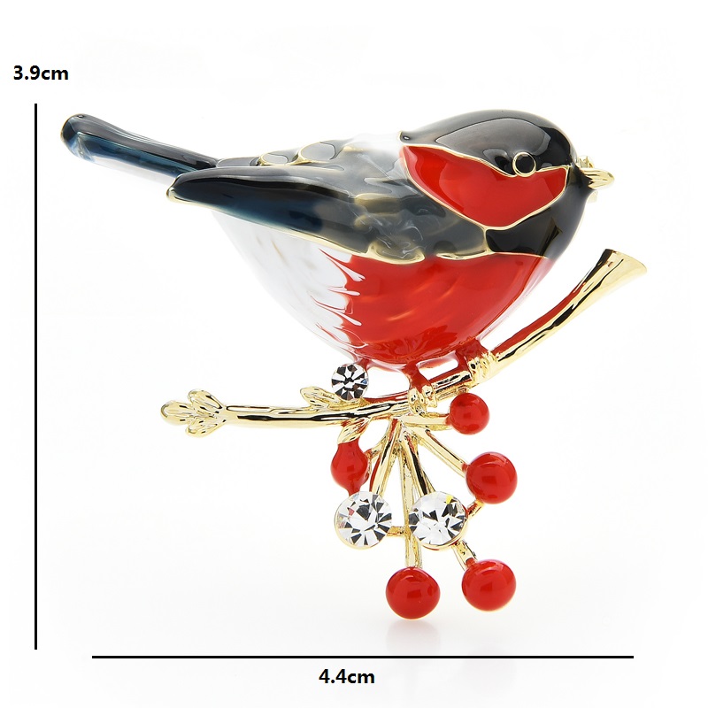 Broche Rouge Gorge en métal émaillé avec plumage rouge, noir et blanc, posée sur une branche dorée ornée de baies rouges et strass transparents