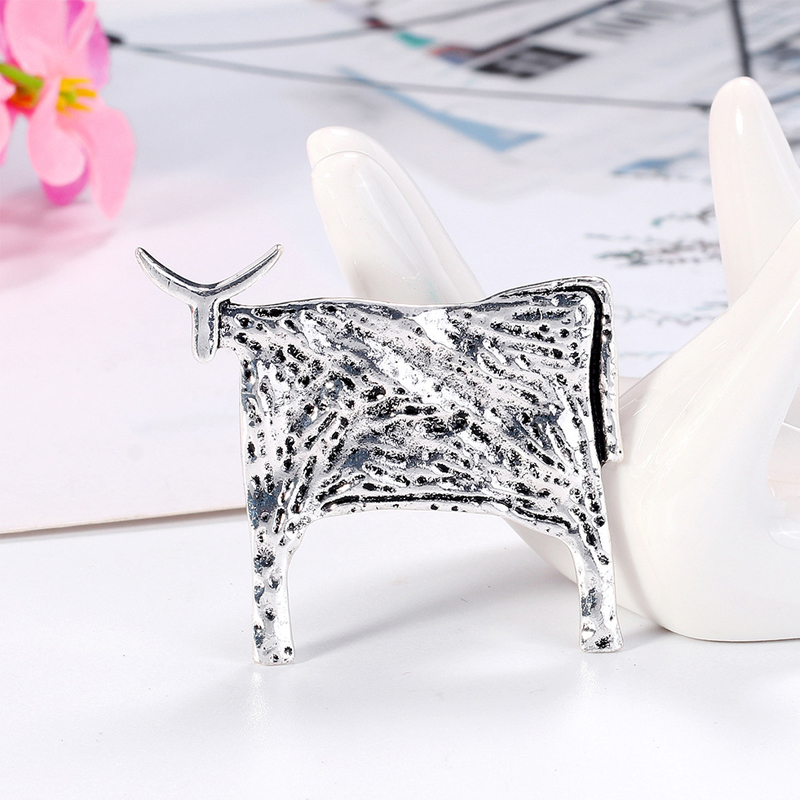 Broche taureau argentée en métal avec texture martelée et finition brillante, vue de côté