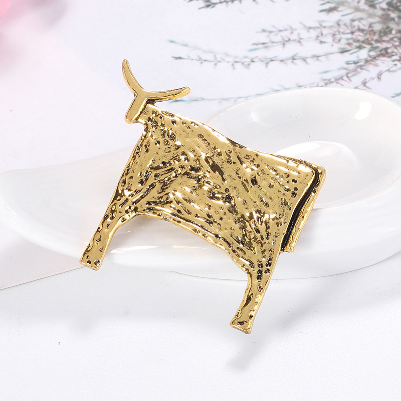 Broche Taureau en métal doré avec texture martelée, vue de profil gauche montrant le détail soigné de la silhouette