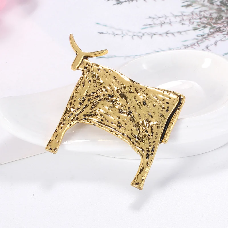 Broche Taureau en métal doré avec texture martelée, vue de profil gauche montrant le détail soigné de la silhouette