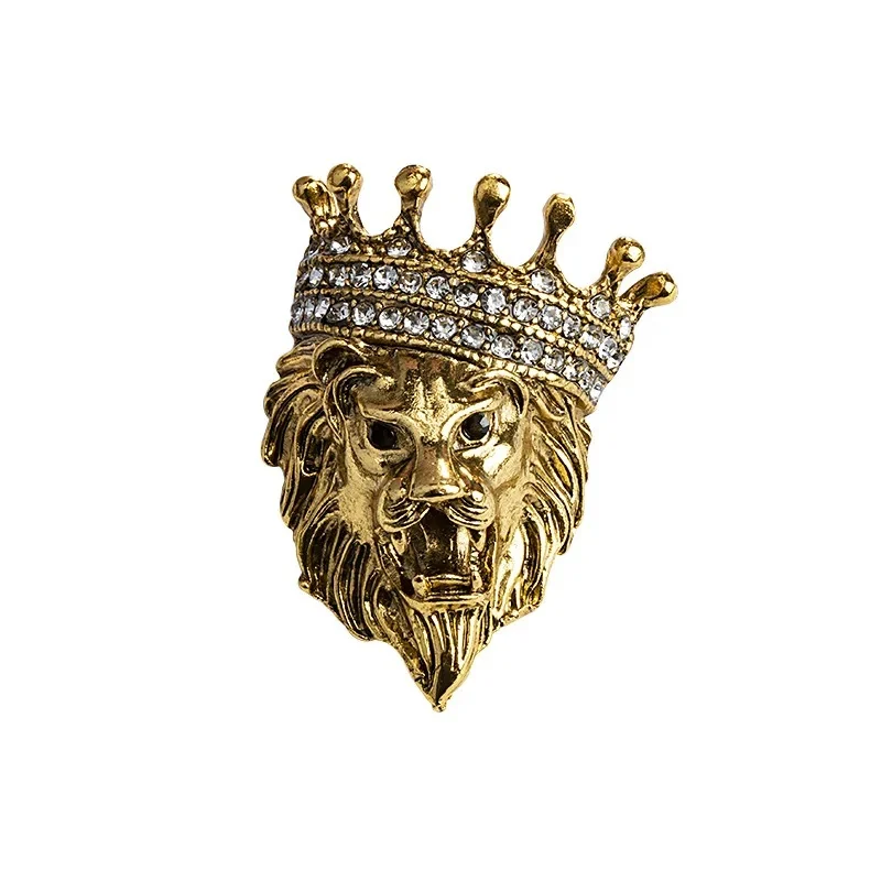 Broche tête de lion en métal doré avec couronne ornée de strass blancs, détail soigné