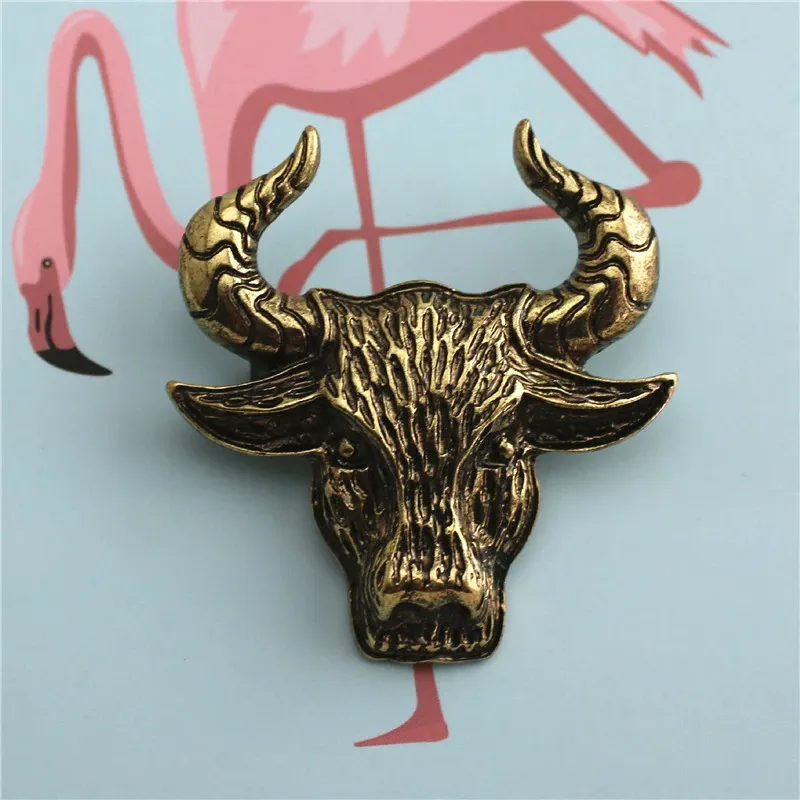 Broche tête de taureau en métal doré avec finition texturée montrant un détail soigné des cornes et du visage