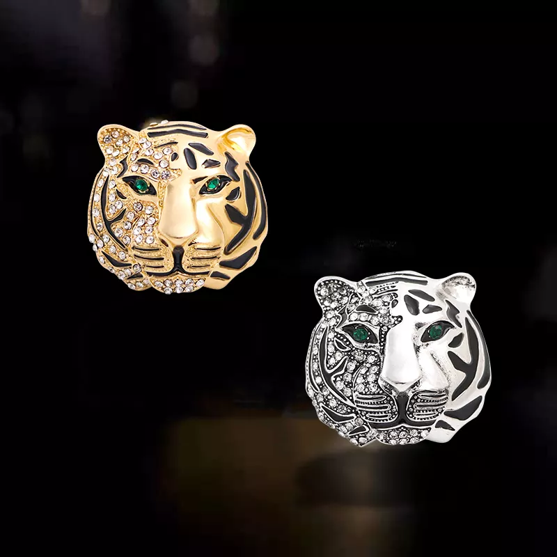 Broche tête de tigre femme en métal doré et argenté avec yeux verts et détails en strass