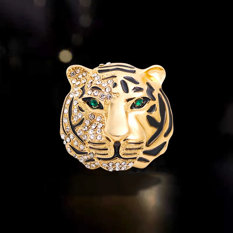 Broche tête de tigre femme en métal doré avec strass et yeux verts, détail du visage avec finition soignée