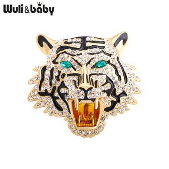 Broche tête de tigre en métal doré avec strass blancs et yeux verts, motif rayé noir, détail soigné et finition élégante
