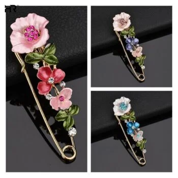 Épingle fleurs en métal doré avec fleurs roses et feuilles vertes, détail soigné des pétales et strass colorés