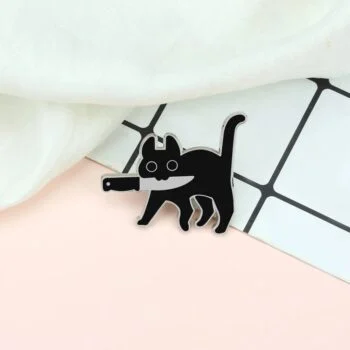 Petit pin's en forme de chat noir en métal avec un design stylisé et des yeux évidés