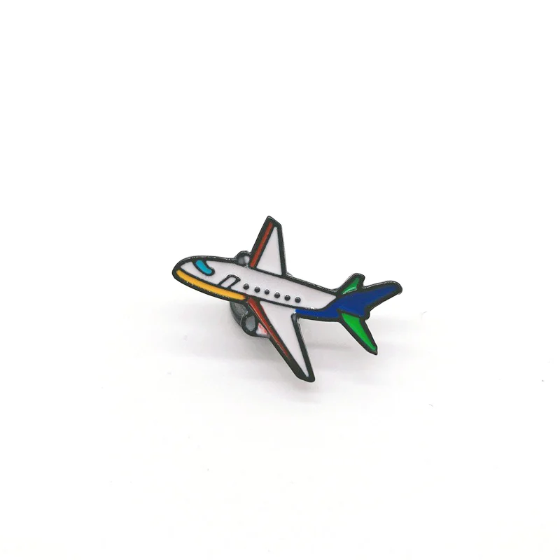 Pin's avion en métal émaillé avec fuselage blanc, ailes grises, queue bleue et verte
