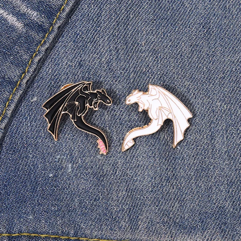 Pin's Double Dragon en métal émaillé noir et blanc avec détails soignés, posé sur tissu jean bleu