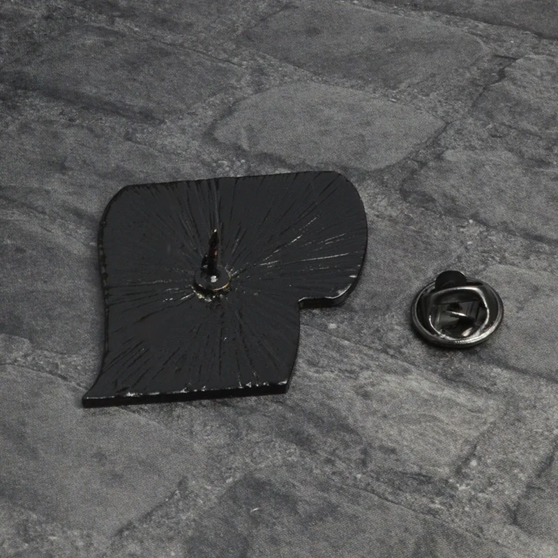 Pin's rouleau de papier toilette noir en métal avec attache papillon, vue de dos sur fond gris