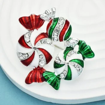 Broche Bonbons De Noel en métal argenté avec émail rouge, blanc et vert, ornée de strass scintillants, détail soigné sur la forme de bonbons torsadés
