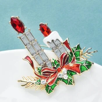 Broche houx et bougies de Noël en métal doré avec émail vert et rouge, pierres rouges et blanches, détail nœud rouge et feuilles de houx