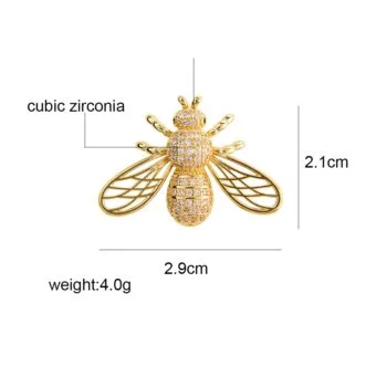 Broche abeille originale en cuivre doré avec zircones cubiques, vue de face montrant les détails des ailes ajourées et du corps pavé de pierres