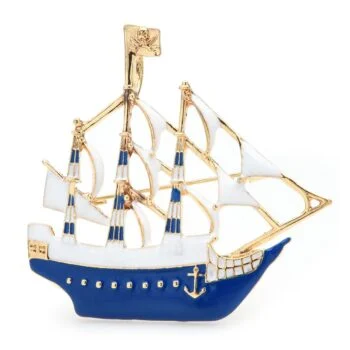 Broche bateau en métal doré avec coque bleue et voiles blanches, détail ancre dorée sur la coque